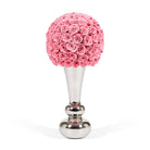 Decorative object with pink rose ball and silver base on a white background